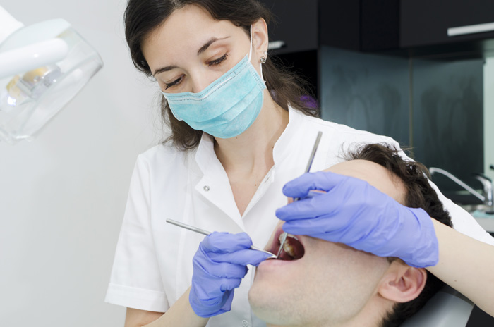 Female dentist looking inside a patient's mouth